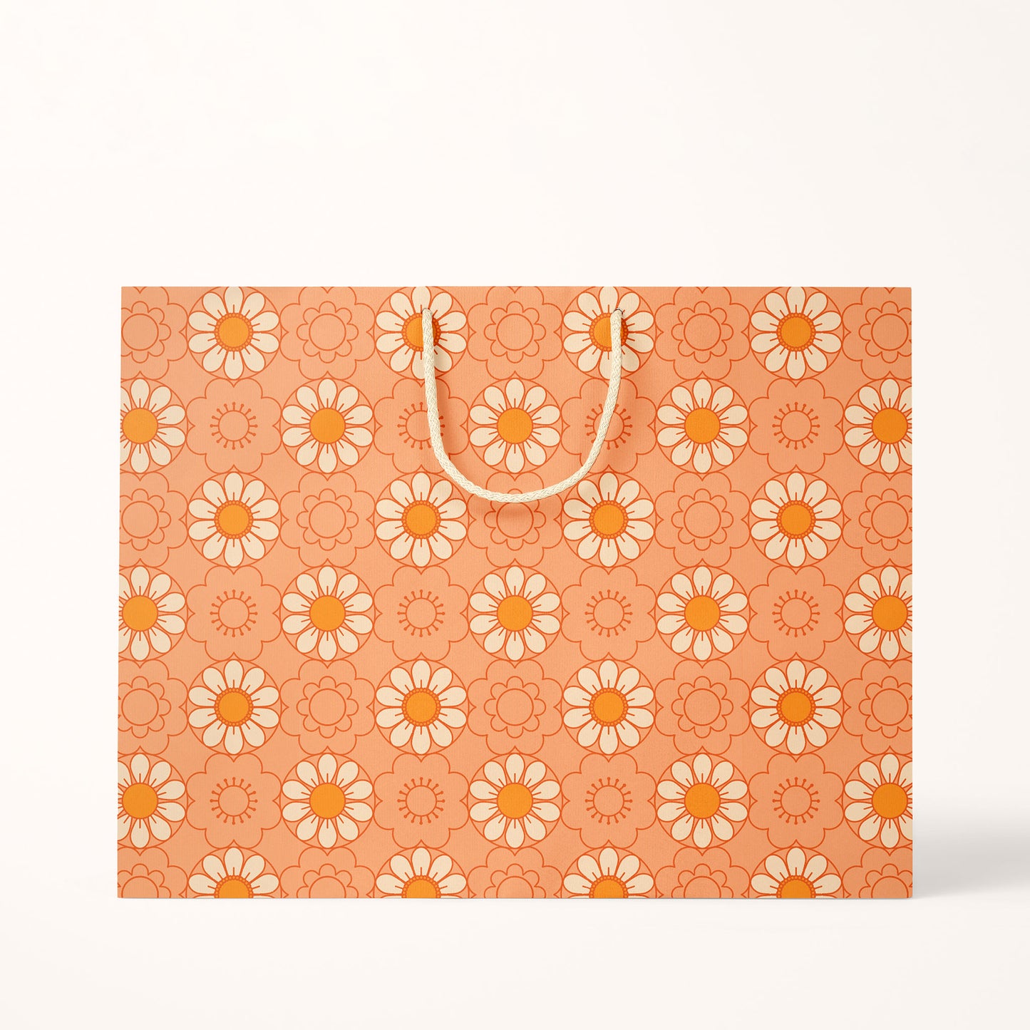 Two different sized paper gift bags with an orange background and a light yellow and orange repeating daisy print. They feature cotton string handles.