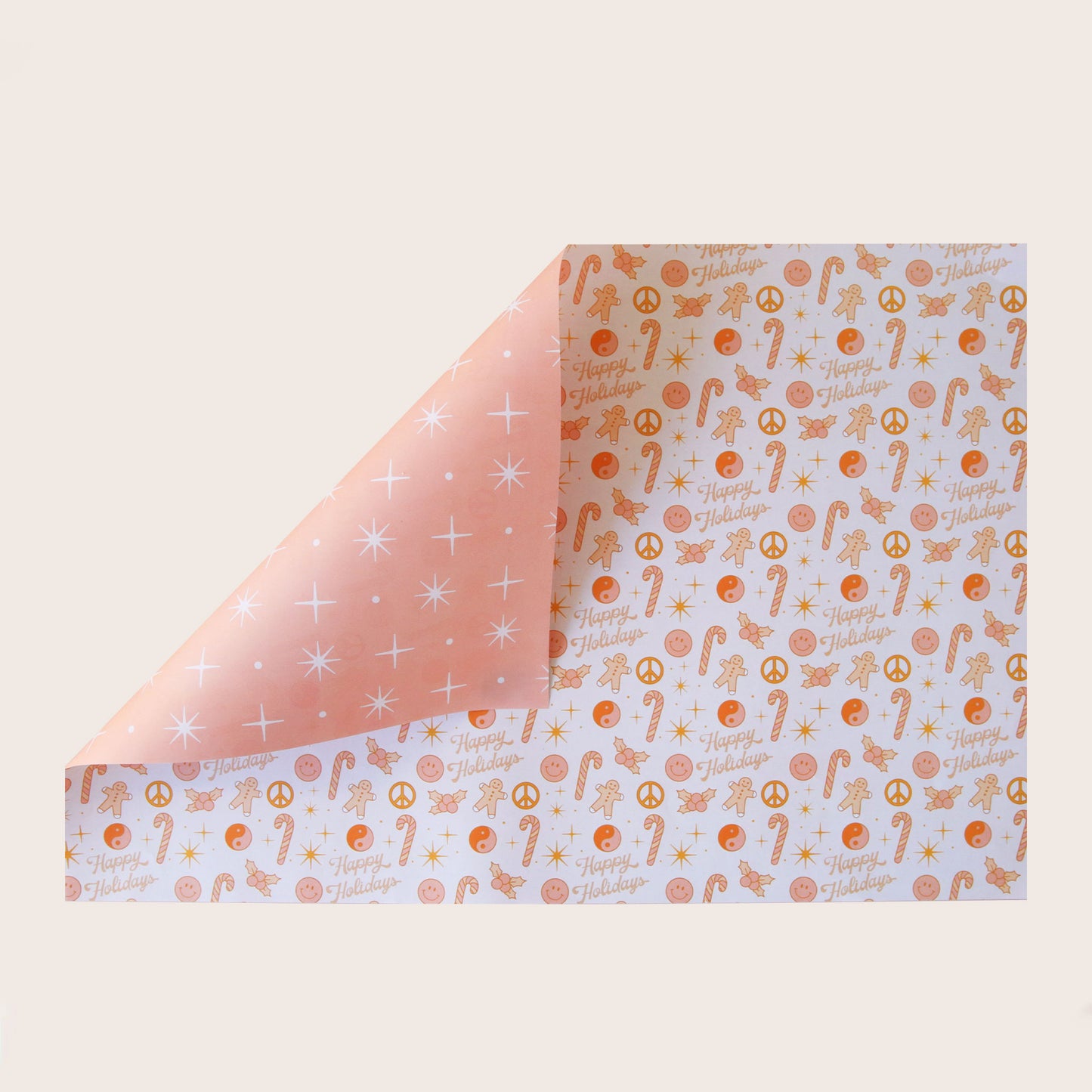 A single sheet of gift wrap with a festive print including gingerbread men, peace signs, candy canes, holly, smiley faces, and dainty "Happy Holidays". The gift wrap is reversible and the side with the print is on a white background while the symbols are shades of pink and orange and the reversible side features a salmon color background and various white stars and twinkle symbols.